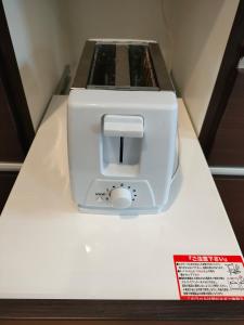 a white toaster sitting on top of a counter at Hakuba Matata Apartment in Hakuba