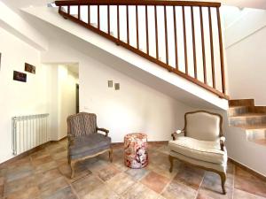 een woonkamer met 2 stoelen en een trap bij Villa Romitello con Piscina Total Relax in Borgetto