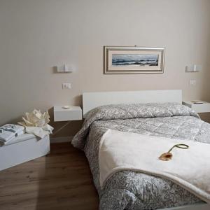 een witte slaapkamer met een bed en twee nachtkastjes bij Room 369 in Termoli