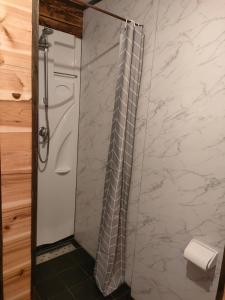 a shower in a bathroom with a white marble wall at Hakuba Matata Apartment in Hakuba