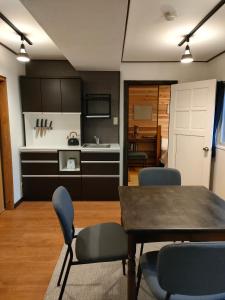 a kitchen and dining room with a table and chairs at Hakuba Matata Apartment in Hakuba