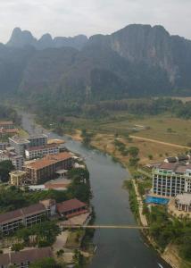 an aerial view of a river with buildings and mountains at Downtown Vang Vieng Hotel in Vang Vieng