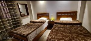 a hotel room with two beds and a mirror at Moon fourteen in Luxor