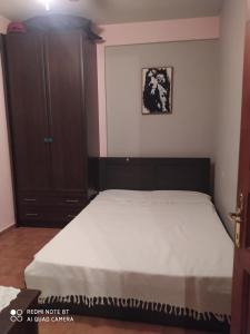 um quarto com uma cama e um armário de madeira em Mamadinas House AlliMpanta em Ammouliani