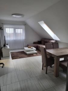 ein Wohnzimmer mit einem Sofa und einem Tisch in der Unterkunft Flower Apartman 5 