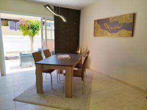 a dining room with a wooden table and chairs at Spacieux Duplex Casa Maya Caleta de Fuste in Caleta De Fuste