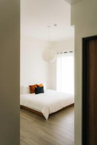 a bedroom with a white bed with a large window at 無處 Nowhere Retreat 獨棟空間 in Yilan City