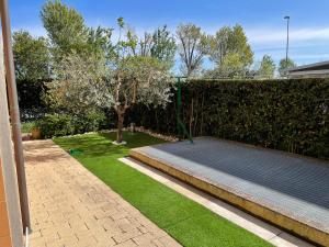 a garden with a tennis court next to a fence at Nichi House in Senigallia