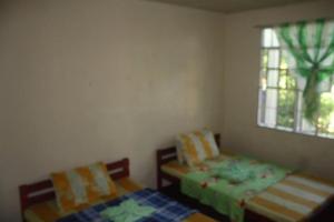 a bedroom with two beds and a window at CVNB guesthouse in San Juan