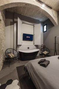 baño con bañera, 1 cama y 2 sillas en Rabat l.o. MDINA-Designer House THE BEDROOM-TUB, en Rabat
