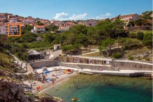 a group of people on a beach near a body of water at Kristina in Vrbnik