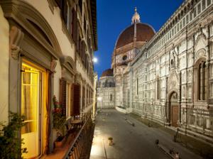 una strada cittadina con edifici e un edificio a cupola di Granduomo Charming Accomodation a Firenze