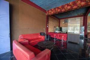 a living room with a red couch and a table at RedDoorz Syariah near Danau Lut Tawar Takengon 2 in Takengon