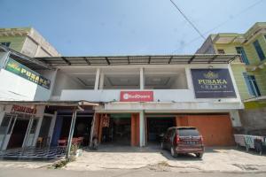 Takengon的住宿－RedDoorz Syariah near Danau Lut Tawar Takengon 2，停在大楼前的汽车