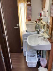 y baño con lavabo y lavadora. en Guest House Hinode, en Takayama
