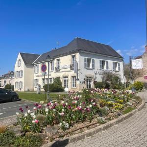 una casa con un jardín de flores delante de ella en Hôtel La Capitainerie, en Châteauneuf-sur-Loire