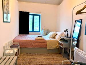 a small bedroom with a bed and a desk at tiny house EFROSSINI in Krásion