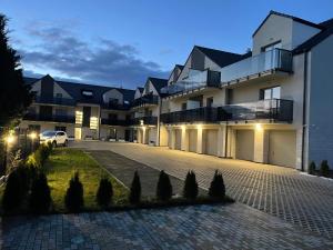 a building with a car parked in front of it at Apartamenty Lambert Grzybowo in Grzybowo