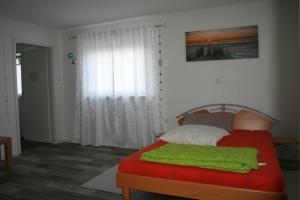 een slaapkamer met een bed met een groene deken erop bij Liebevolle Fewo im Bayerischen Wald in Witzmannsberg