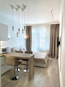 a kitchen and living room with a table and a bed at Апартаменти Корфу біля моря in Odesa
