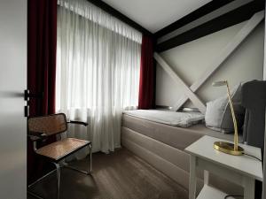 ein Schlafzimmer mit einem Bett, einem Stuhl und einem Schreibtisch in der Unterkunft Neues Exclusives 2 Schlafzimmer Apartment Hamburg in Hamburg