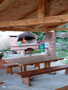 a picnic table in front of a brick oven at Apartment Rural Podastrana in Sinj