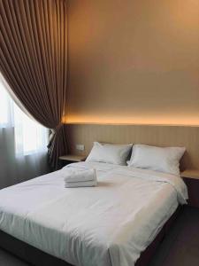 um quarto com uma grande cama branca e uma janela em ND Minimalistic 2BR Suite Amber Cove Melaka Town em Malaca