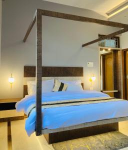 a bedroom with a large bed with blue sheets at The Lavish Stay in Varanasi