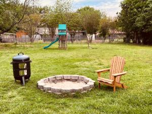 a park with a fire pit and a bench and a playground at The Lil' Yellow Door8 in Durant