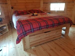 1 dormitorio con 1 cama en una cabaña de madera en Kota SHANTYHOME, en Saint-Martin-dʼArc
