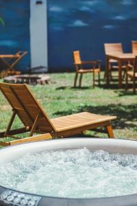 einen Liegestuhl sowie einen Tisch und Stühle in einem Whirlpool in der Unterkunft Apartmány Natálie in Franzensbad