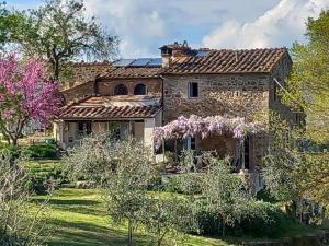 uma casa de pedra com um jardim em frente em Agriturismo Timignano em Monteguidi