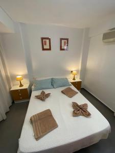 a bedroom with a bed with two towels and two lamps at Apto POSEIDON CON PARKING EN EDIFICIO SUBTERRANEO in Cullera