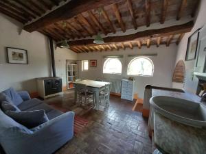 uma sala de estar com um sofá, uma mesa e 2 janelas em Agriturismo Timignano em Monteguidi