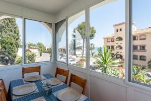 Un comedor con mesa y sillas y ventanas. en Superbly situated villa 67, en Mijas Costa