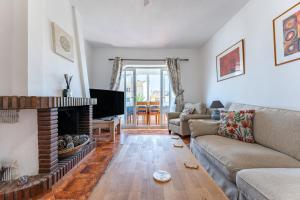 Una sala de estar con un sofá y una chimenea. en Superbly situated villa 67, en Mijas Costa