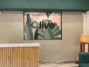 a painting on a wall with the words live on it at Olive Indiranagar Metro - by Embassy Group in Bangalore