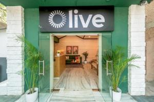 a store entrance with plants in front of it at Olive Indiranagar Metro - by Embassy Group in Bangalore