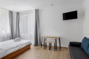 ein Schlafzimmer mit einem Bett, einem Tisch und einem Sofa in der Unterkunft DD Boutique Apartments in Cluj-Napoca