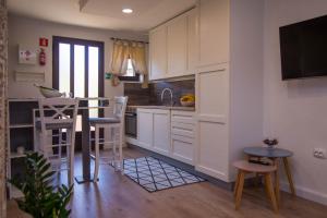 a kitchen with white cabinets and a table and chairs at Bato A2+1 in Veli Lošinj