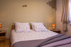 a bedroom with a bed with two pillows and two lamps at Bato A2+1 in Veli Lošinj