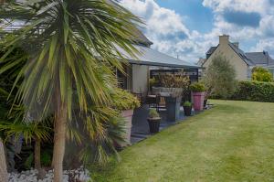 a house with a palm tree in the yard at Kerivin in Le Conquet