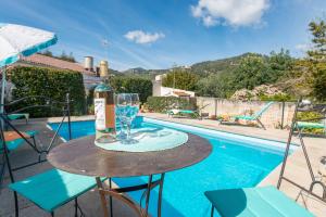 - une table avec un verre de vin à côté de la piscine dans l'établissement Construcciones Balaguer, à Mancor del Valle