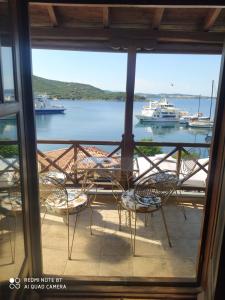 uma vista para uma varanda com cadeiras e barcos na água em Mamadinas House AlliMpanta em Ammouliani