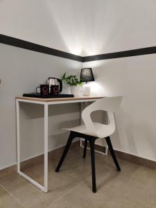 a white desk with a chair and a lamp at Olive Indiranagar Metro - by Embassy Group in Bangalore