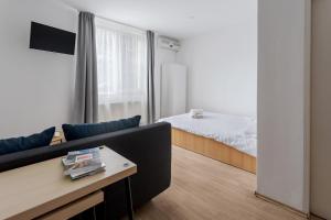a living room with a couch and a bed at DD Apartments - Tarnavelor in Cluj-Napoca