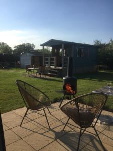 two chairs and a fire pit in a yard at Woodman's Rest in Kirdford