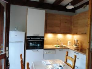 een keuken met een witte koelkast en een tafel bij Le Chamois in Arêches