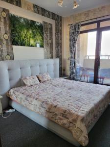 a bedroom with a large bed with a large window at Lazuren Bryag Lux suite in Burgas