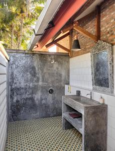 a bathroom with a sink and a brick wall at Les Rizieres Lombok - Tetebatu in Tetebatu
